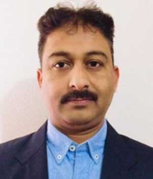 Dr. Gururaj M. Neelgund, a visiting adjunct faculty member, featured in a professional photograph against a plain backdrop