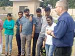 Workshop on CFFP at FCRC, JAIN (Deemed-to-be University). A group of people gathered around a decorative outdoor area, examining and discussing the design.